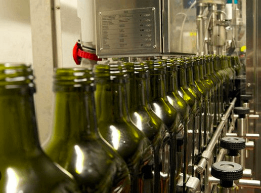 Green glass bottles on the filling line